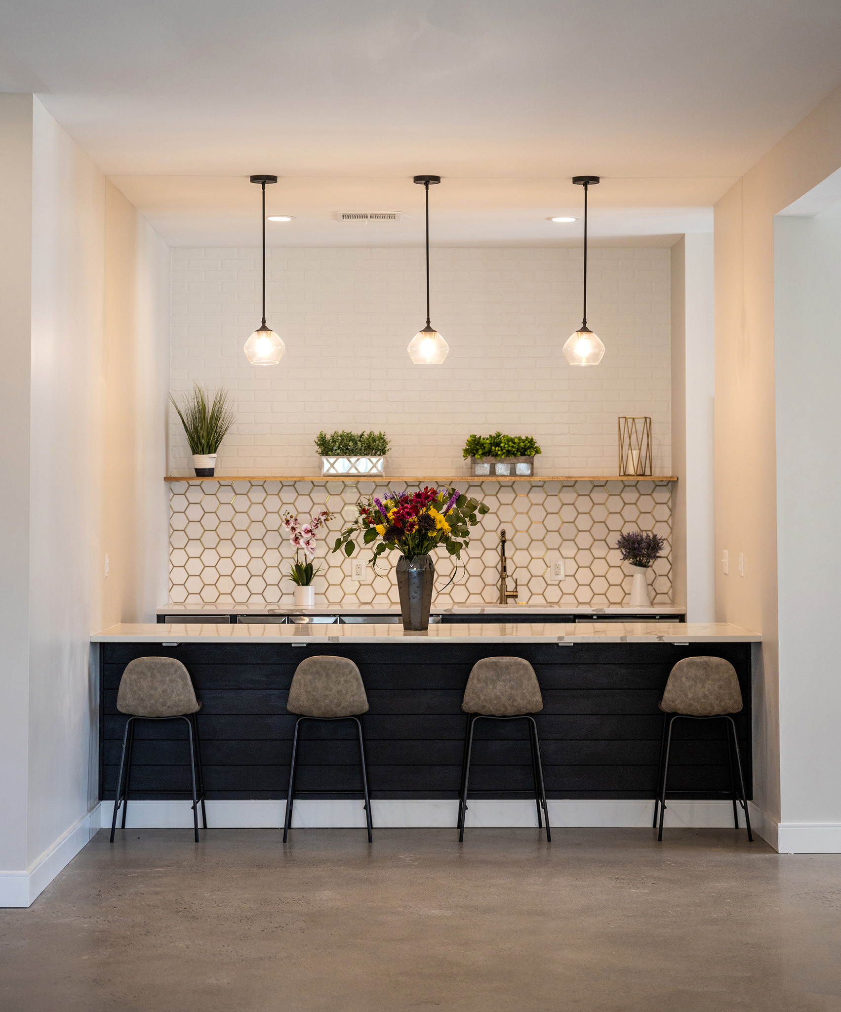 a kitchen with a counter and three stools
